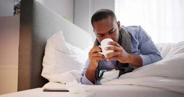 Kranker Mann Sitzt Auf Bett Und Hält Tasse Tee — Stockfoto