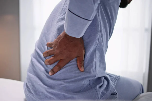 Mann Sitzt Bett Und Leidet Unter Rückenschmerzen — Stockfoto