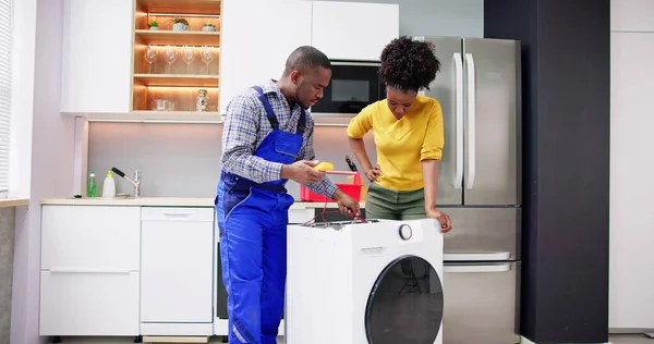 Νεαρός Αφρικανική Αμερικανική Τεχνικός Επισκευή Πλυντήριο Ρούχων Στην Κουζίνα — Φωτογραφία Αρχείου