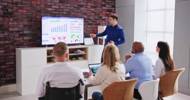 Businesspeople Looking At Businessman Giving Presentation In Meeting