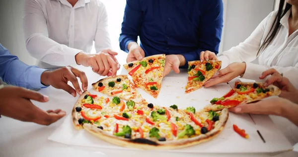 Friends Eating Pizza At Office Table Indoors