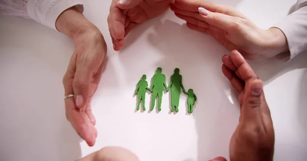 Close Van Een Bedrijf Hand Protecting Family Figure Cut Out — Stockfoto