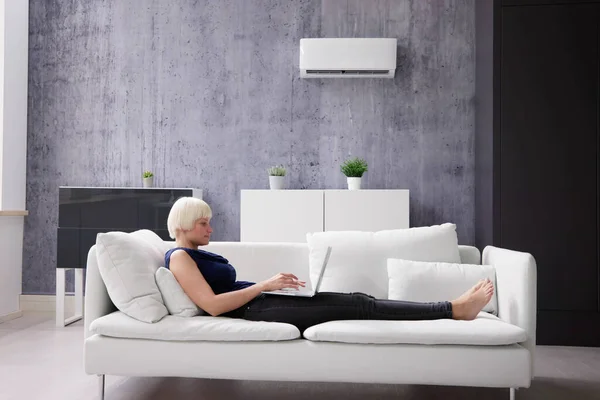 Young Happy Woman Lying Air Conditioner Couch Using Laptop Home — Stock Photo, Image