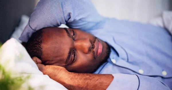 ベッドに横たわっ熱に苦しんでいる若いアフリカ人男性 — ストック写真