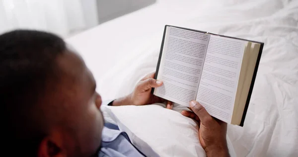 Gelukkig Jonge Afrikaanse Man Lezen Van Zijn Boek Bed — Stockfoto