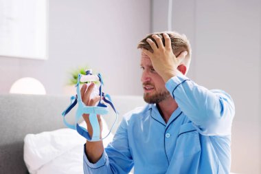 Şok Olan Genç Adam CPAP Makine Maskesi Tutuyor