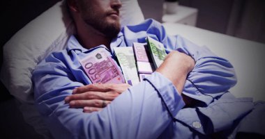 Para birimi notlar bohça ile yatakta uyuyan adam