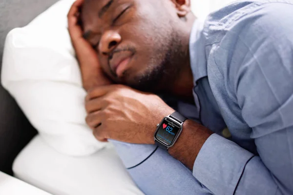 男人睡在一起显示心跳率他手中的智能手表 — 图库照片