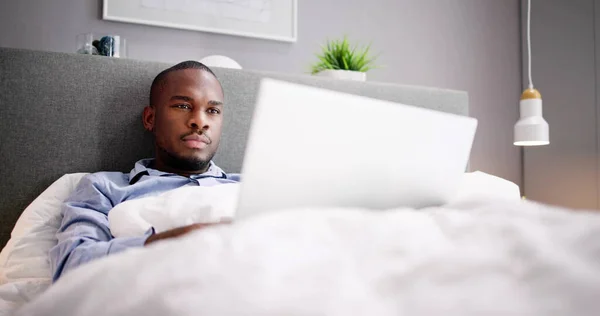 Yatakta Oturan Mutlu Adam Dizüstü Bilgisayar Kullanıyor — Stok fotoğraf