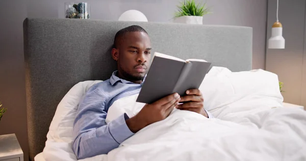 Mutlu Genç Afrika Adam Yatakta Onun Kitap Okuma — Stok fotoğraf