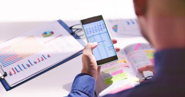 Gantt App ve takvim yazma programı ile cep günlüğü ile kalem tutan işadamı