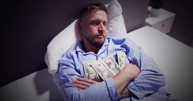 Para birimi notlar bohça ile yatakta uyuyan adam