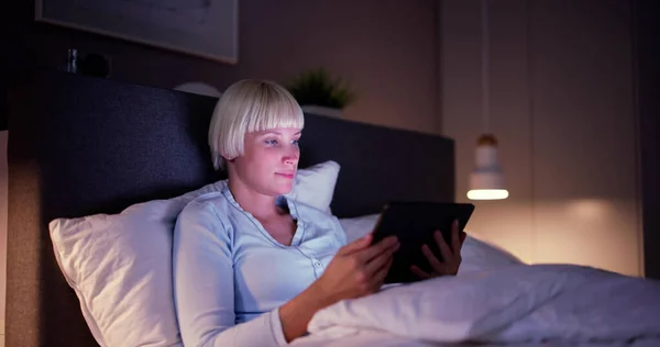 Kobieta Leżąca Łóżku Patrząc Oświetlone Tabletki Cyfrowe — Zdjęcie stockowe