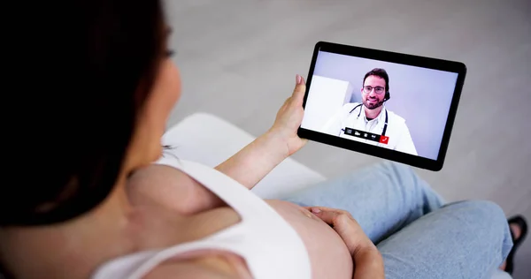 医師とのオンラインビデオ会議コールで妊娠中のカップル — ストック写真