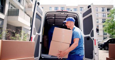 İki genç erkek Movers kamyondan karton kutu taşıma