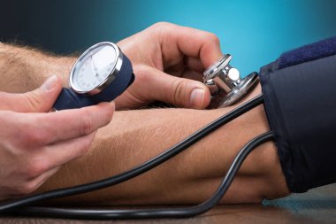 Erkek doktor hasta masada kan basıncı kontrol görüntü kırpılmış