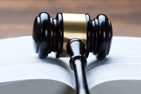 Closeup of mallet on open legal book at table in courtroom