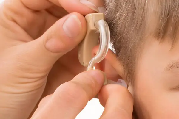 Närbild Läkare Montering Hörapparat Leende Pojkens Öra — Stockfoto