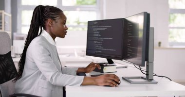 Afrika kökenli Amerikalı programcı masadaki bilgisayarı kullanıyor. Web Geliştirici Kadın