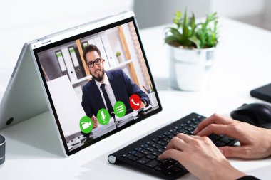 Ofiste dizüstü bilgisayarda görüntülü sohbet alan kadın