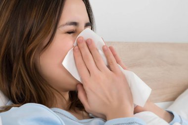 Genç kadın soğuk burnunu mendilin üfleme ile enfekte