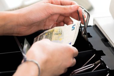 Bayan kasiyer süpermarkette kasa çekmecede değiştirmek için arama yüksek açılı görünüş