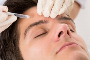 Güzellik Kliniğinde yüz gerdirme tedavisi gören genç adam.