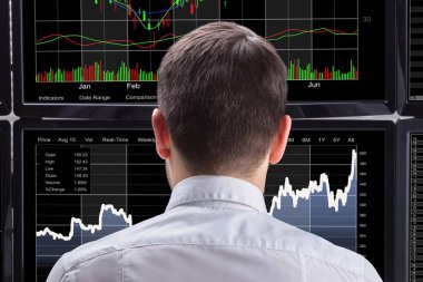Grafikler birden çok bilgisayar ekranlarında analiz bir genç erkek borsa Broker yan görünüm