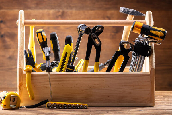 Toolbox With Various Worktools On Wooden Surface