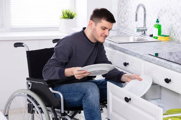 Junger Glücklicher Behinderter Sitzt Rollstuhl Und Sortiert Teller Schublade — Stockfoto