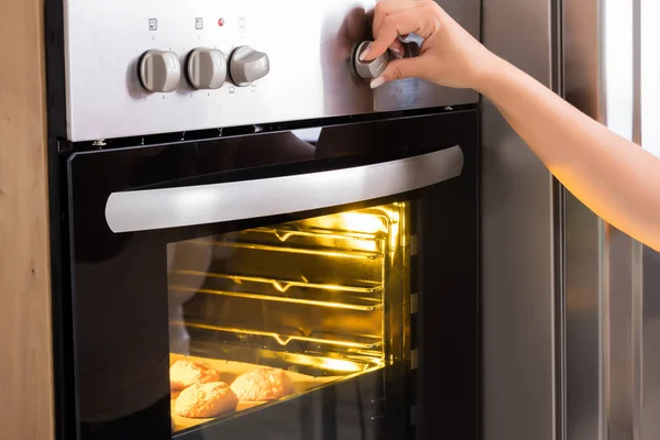 stock image Young Woman Using Microwave Oven For Baking Fresh Cookies In Kitchen