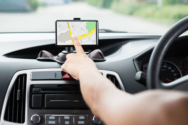 Крупный план женской руки с помощью GPS навигации внутри автомобиля
