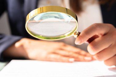Sözleşme formunu Büyüteç aracılığıyla bakarak bir iş kadını'nın el Close-up
