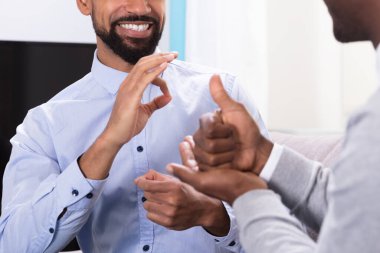 İşaret dilleri yapma kanepede oturan iki mutlu delikanlı