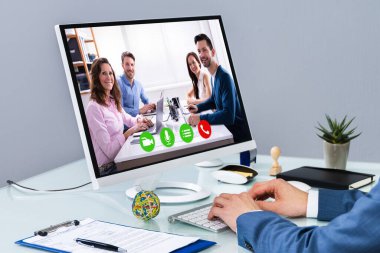 İşadamı, bilgisayardaki iş arkadaşlarıyla görüntülü konferans yapıyor.