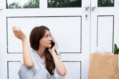 Bir Korkmuş Genç Kadın Cep Telefonu Konuşurken Kapı Dışında Oturan