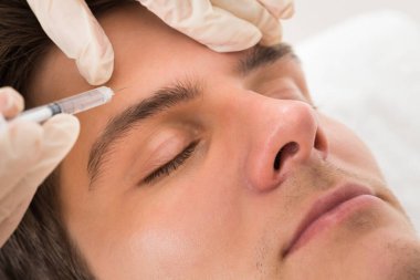 Güzellik Kliniğinde yüz gerdirme tedavisi gören genç adam.