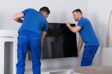 Üniformalı İki Genç Erkek Taşıyıcı Oturma Odasına Televizyon Yerleştirme