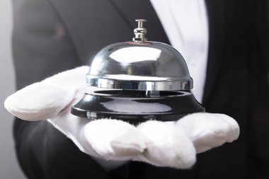 Bir garsonun el hizmet Bell tutarak Close-Up