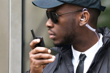 Genç Afrika erkek telsiz üzerinde konuşurken güvenlikçi portresi
