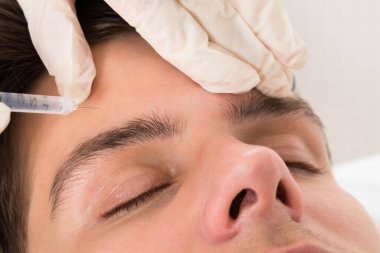 Güzellik Kliniğinde yüz gerdirme tedavisi gören genç adam.