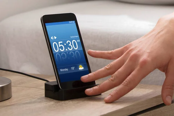 Woman Turning Off The Alarm On Cell Phone While Waking Up In The Morning