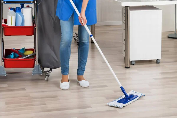 stock image Full length portrait of happy female janitor mopping floor in office