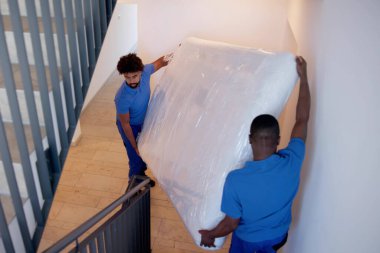 Yatak Kaldırma ve Teslimat. Taşıyıcı İnsanlar Paketli Döşek
