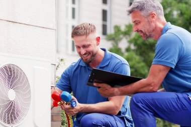 Experienced Technician Repairing Air Conditioning System with Heat Pump clipart