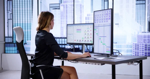 在电脑屏幕上使用日历日程的女商人 — 图库照片