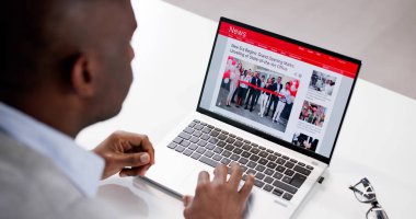 Dizüstü bilgisayardaki haber başlığını okuyorum. Çevrimiçi Web Sitesi