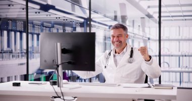 Klinikte bilgisayar kullanan kendinden emin bir doktorun portresi.