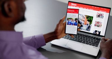 Cep telefonu ve dizüstü bilgisayarda online haber makalesi izliyorum. Elektronik Gazete