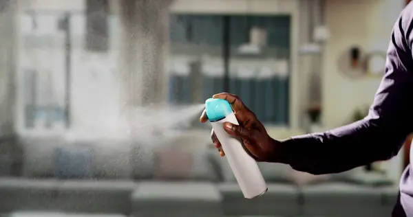 Африканский Человек Использует Воздушный Спрей Гостиной — стоковое фото